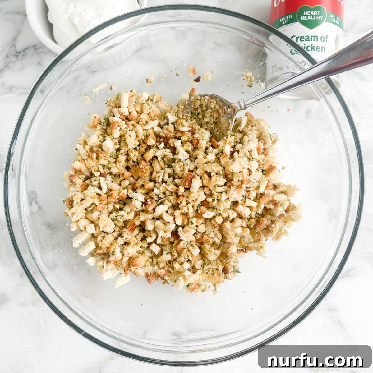 Comforting Chicken Zucchini Bake 6 A medium-sized bowl filled with a perfectly prepared stuffing mix, golden and buttery, ready to be spread over the casserole. The crumbs are moist and fragrant, promising a crispy, flavorful topping.