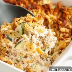 Comforting Chicken Zucchini Bake 10 Spoon scooping out chicken zucchini squash casserole.