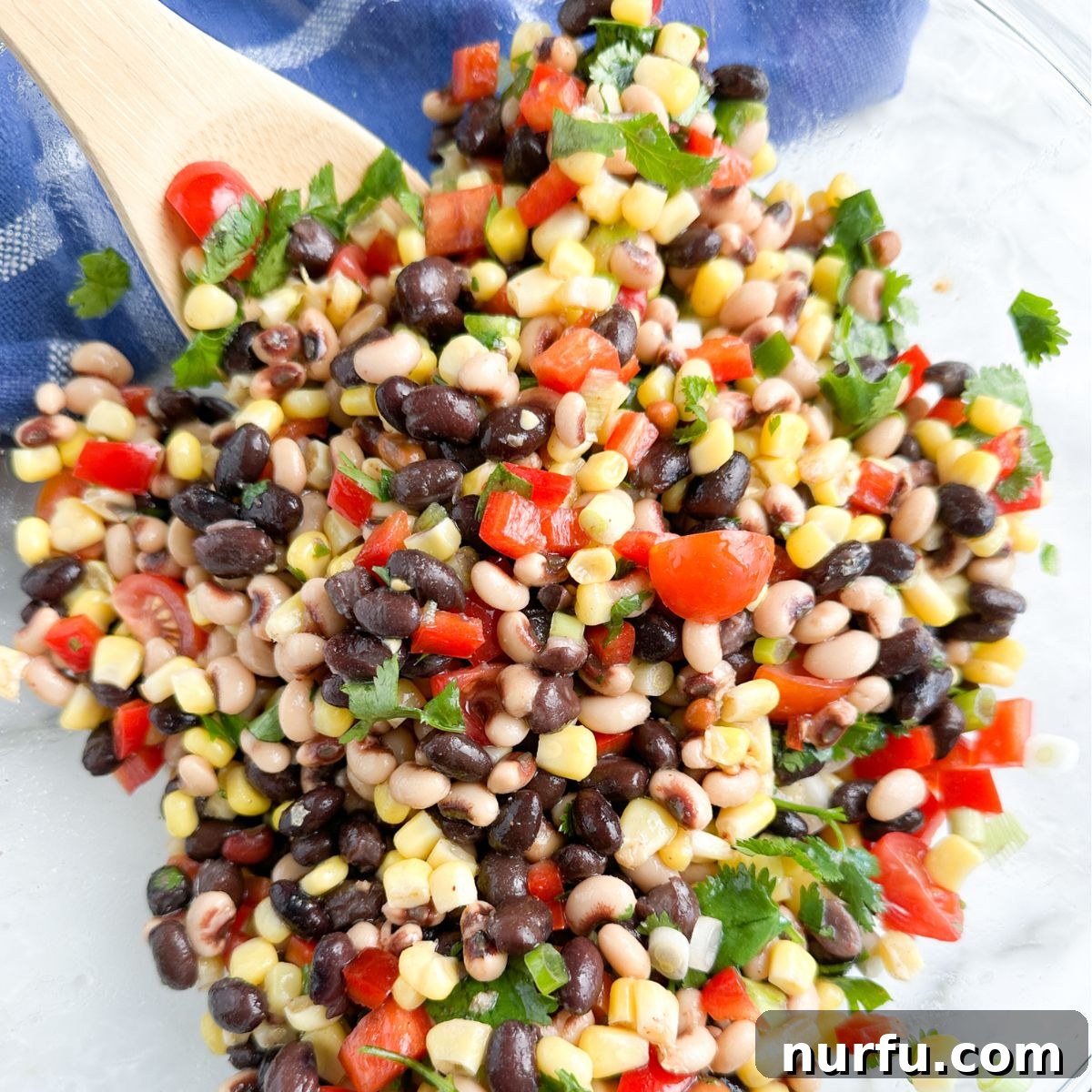 Savoring Freedom: 37 Delicious Memorial Day Recipes 11 A colorful bowl filled with fresh Texas caviar, showcasing a mix of beans, corn, peppers, and tomatoes, ready to be scooped.