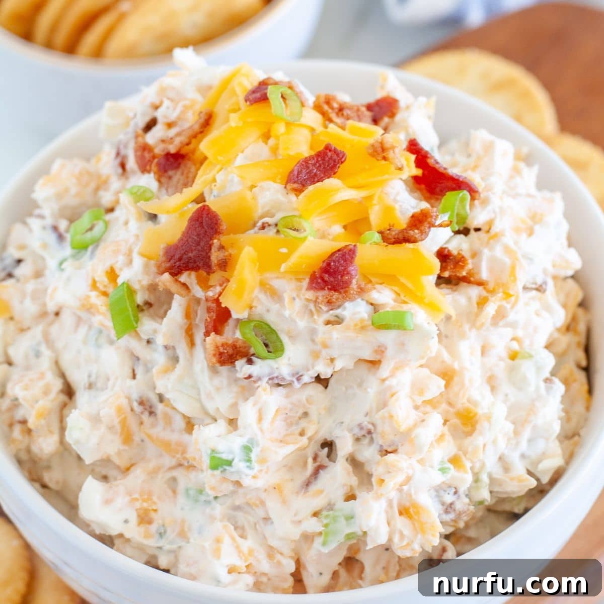 Savoring Freedom: 37 Delicious Memorial Day Recipes 4 A rich and creamy crack dip, adorned with a sprinkle of shredded cheese and crispy bacon bits, ready for dipping.