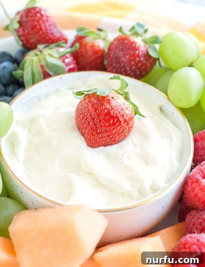 Savoring Freedom: 37 Delicious Memorial Day Recipes 35 A bowl of luscious cream cheese fruit dip, surrounded by an assortment of fresh, vibrant fruits, ready for a healthy snack or dessert.