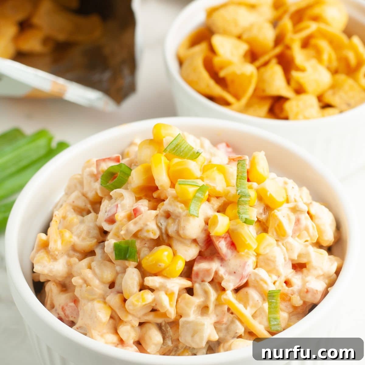 Savoring Freedom: 37 Delicious Memorial Day Recipes 9 A generous bowl of creamy corn dip with cream cheese, accompanied by a smaller bowl of crunchy corn chips, ready for a gathering.