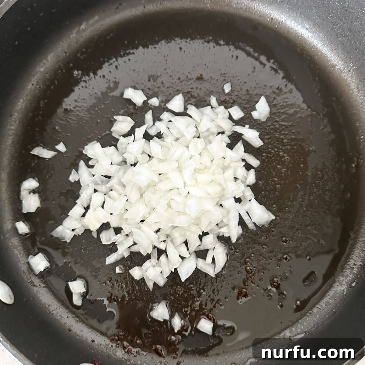 Skillet with diced onion cooking until softened.