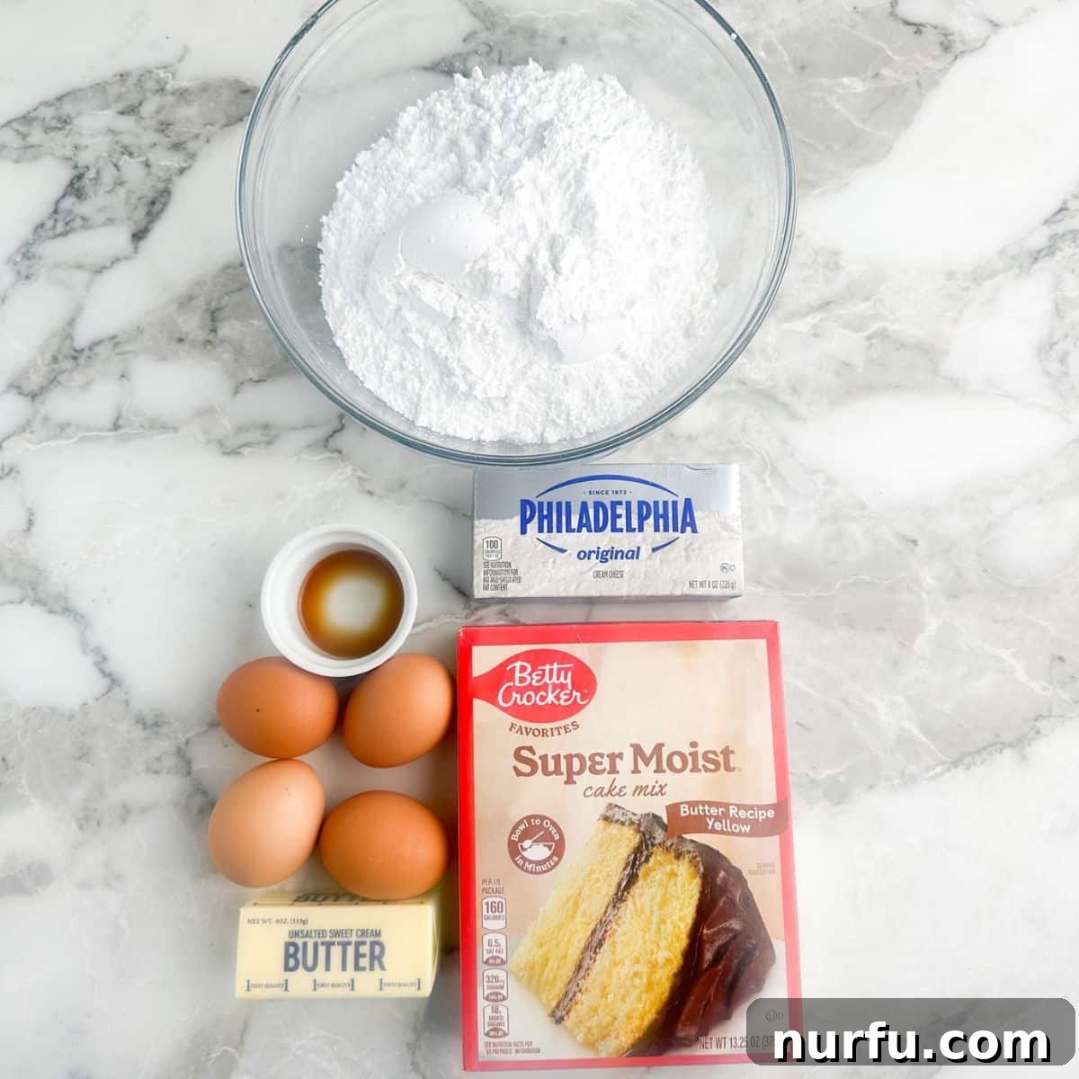 A collection of the essential ingredients for Chess Squares, including a box of cake mix, eggs, softened cream cheese, butter, and powdered sugar, neatly arranged in separate bowls.
