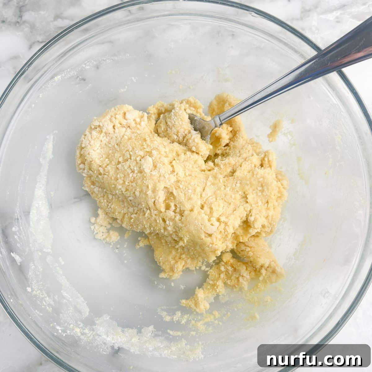 Bowl of buttery cake mix dough, ready to be pressed into a crust.