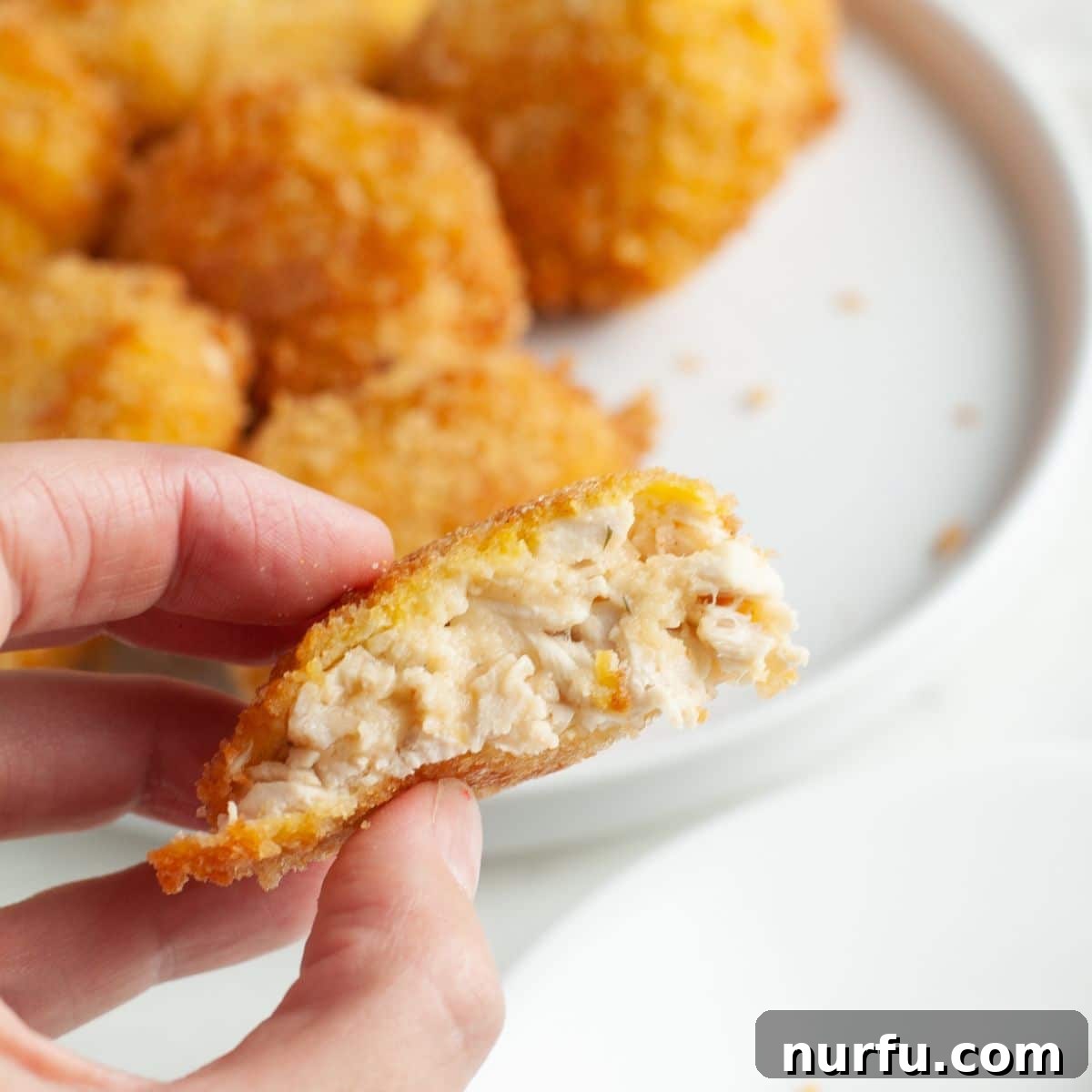 Crispy Golden Chicken Croquettes 11 A hand holding a perfectly golden-brown, crispy chicken croquette, showing its inviting texture.