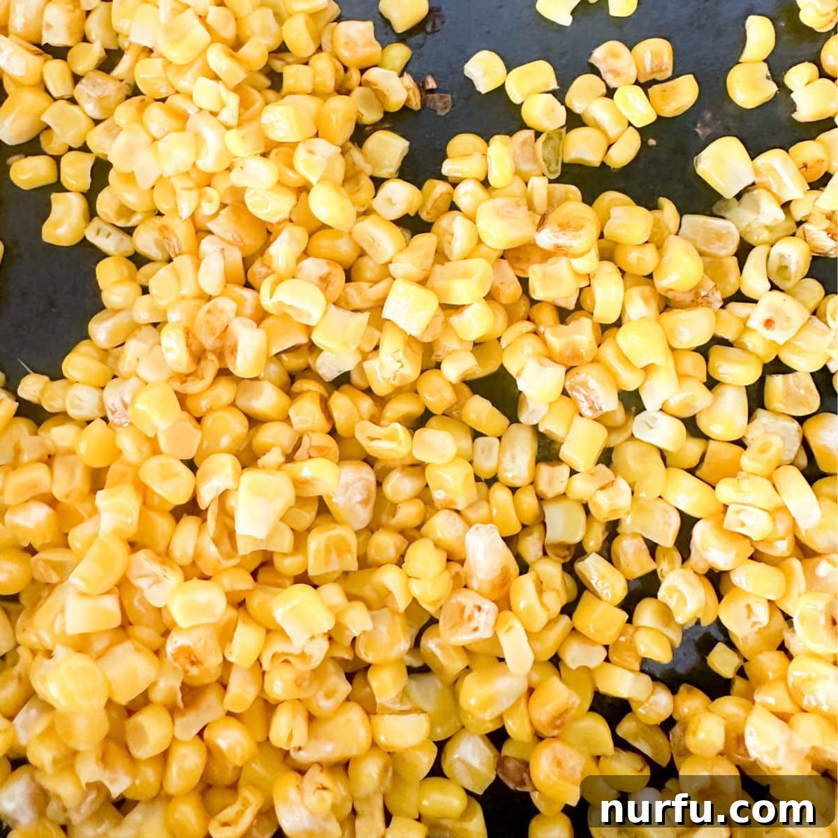 Elote Fiesta Pasta 4 Close-up shot of cooked corn in a skillet, showing a slight char, adding depth of flavor to the elote pasta salad.