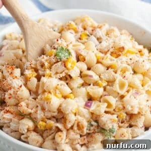 Elote Fiesta Pasta 8 Bowl of elote pasta salad with a wooden spoon.