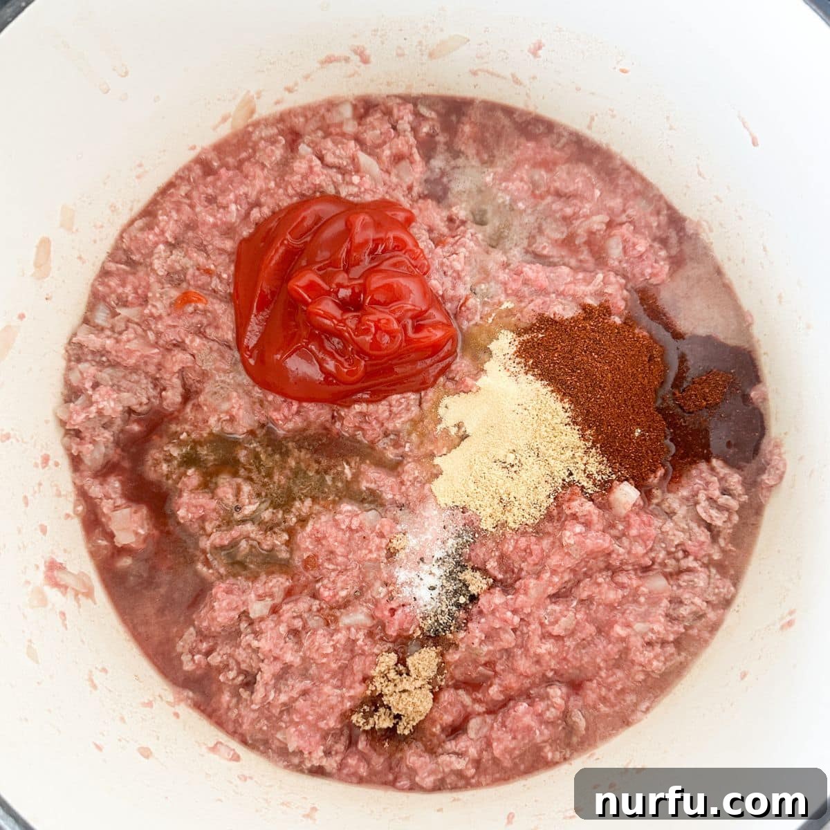 Ultimate Chili Dog Sauce 5 Pot with ground beef, ketchup, and various spices being mixed.
