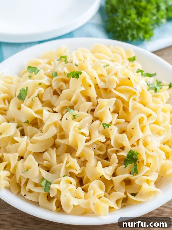 Buttered Noodles Buttered Noodles with fresh parsley in a white bowl, ready to be served.