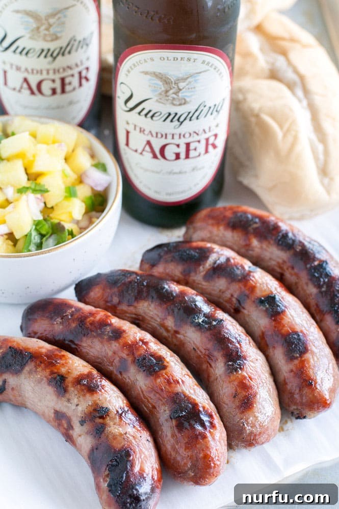 grilled bratwurst Freshly grilled bratwursts resting on a platter, showcasing their perfect char and golden-brown hue.