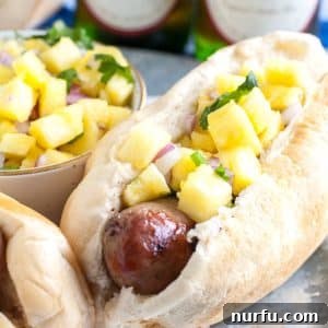 Bratwurst Goes Tropical 3 Sausage in hot dog bun topped with pineapple salsa.