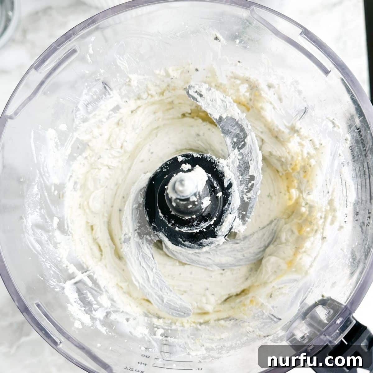 Sun-Kissed Bruschetta Topping 5 A food processor bowl shows the blended, smooth, and creamy mixture of cream cheese and Boursin, ready for serving as the dip base.