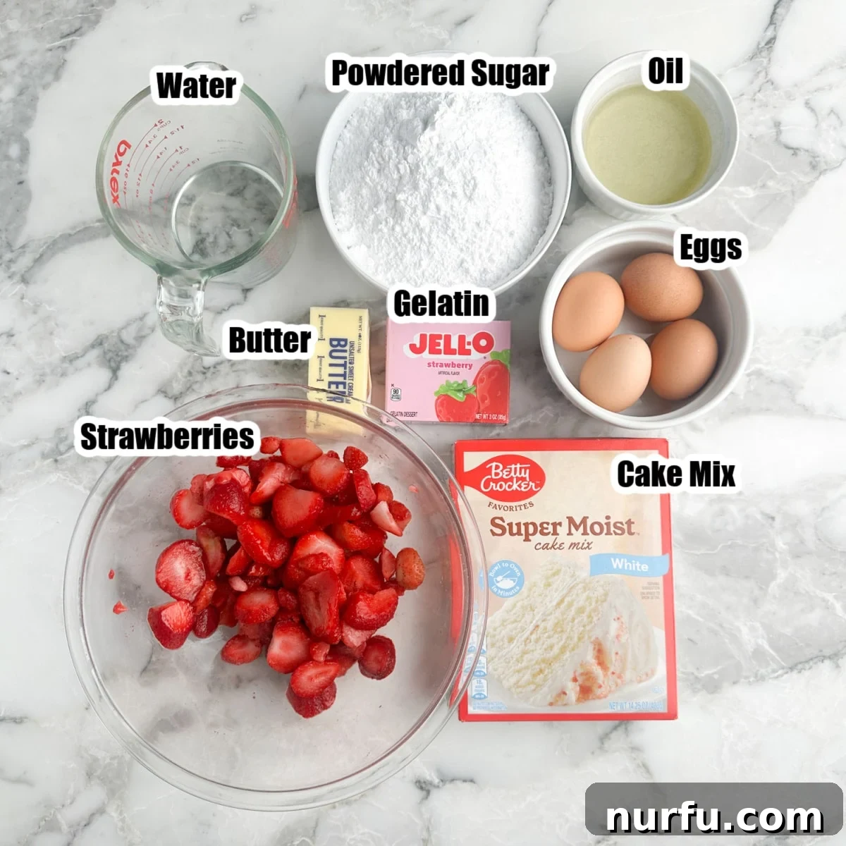 Ingredients laid out: boxed cake mix, a bowl of fresh strawberries, eggs, butter, powdered sugar, oil, strawberry gelatin, and water.