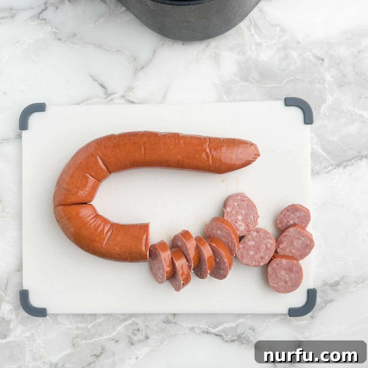 Crispy Air Fryer Kielbasa 4 Cutting board with perfectly sliced kielbasa, ready for the air fryer.