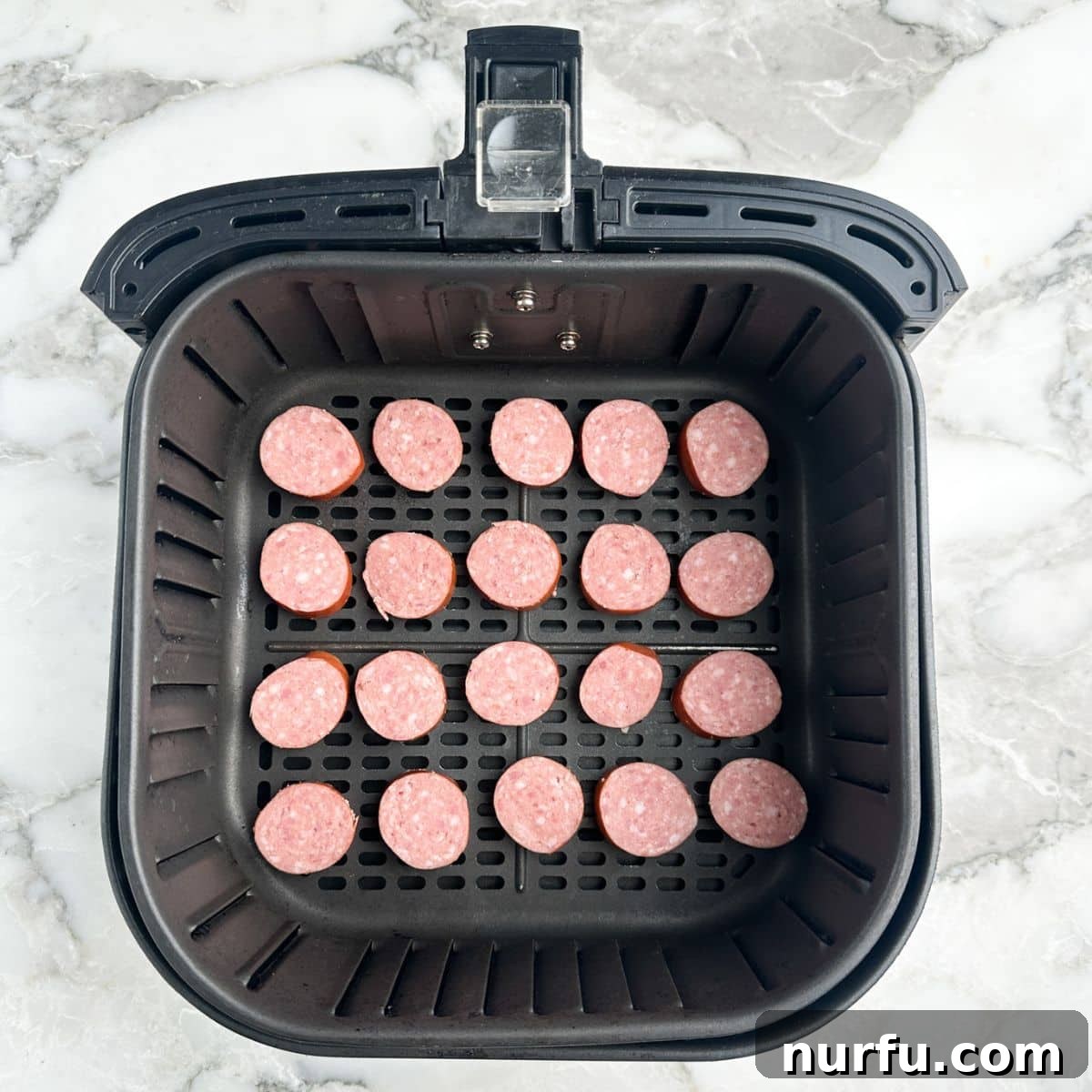 Crispy Air Fryer Kielbasa 5 Air fryer basket neatly filled with sliced kielbasa in a single layer.