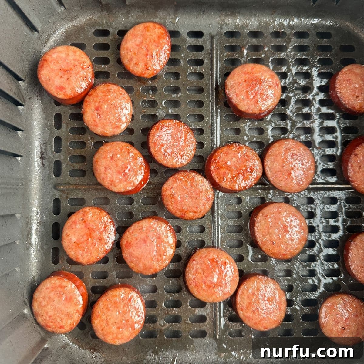 Crispy Air Fryer Kielbasa 6 Air fryer basket filled with beautifully cooked kielbasa, golden and crispy.