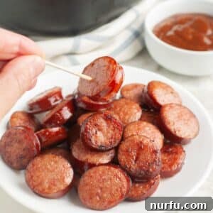 Crispy Air Fryer Kielbasa 8 Plate of kielbasa rounds with a hand holding one on a toothpick.