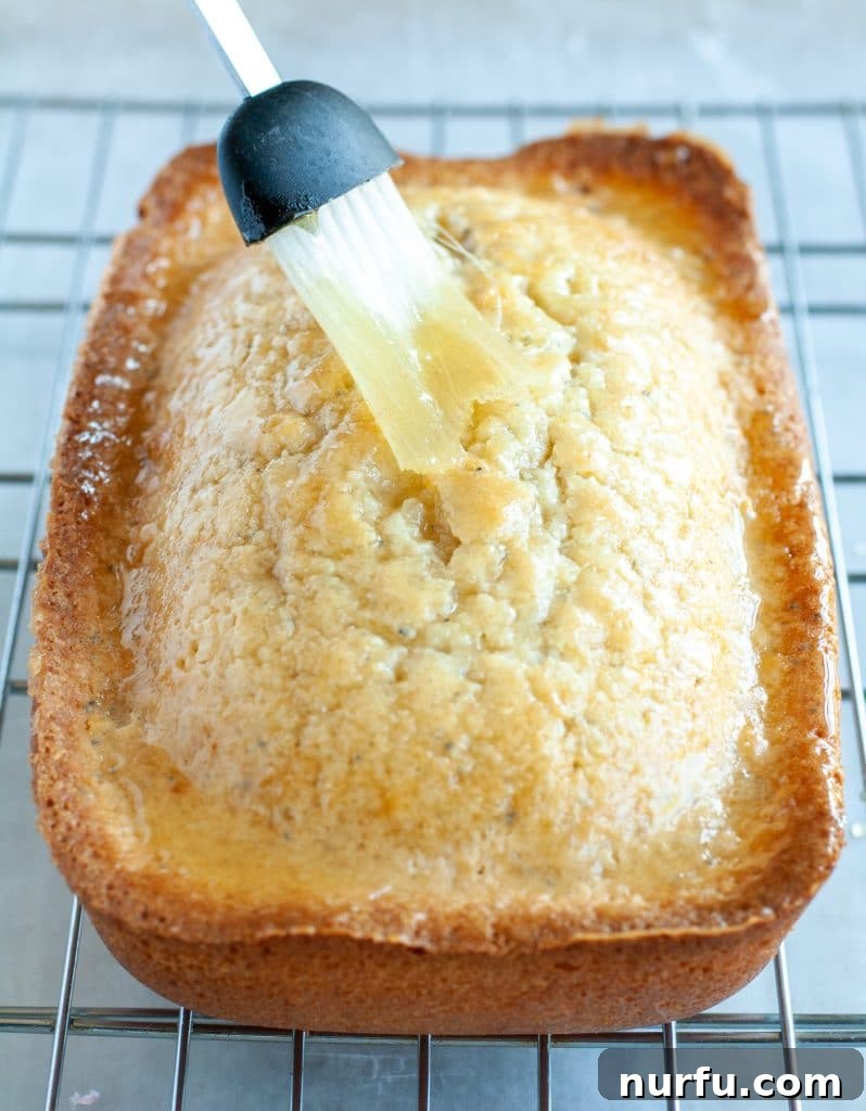 Classic Almond Poppy Seed Cake 3 Glaze being brushed on cake
