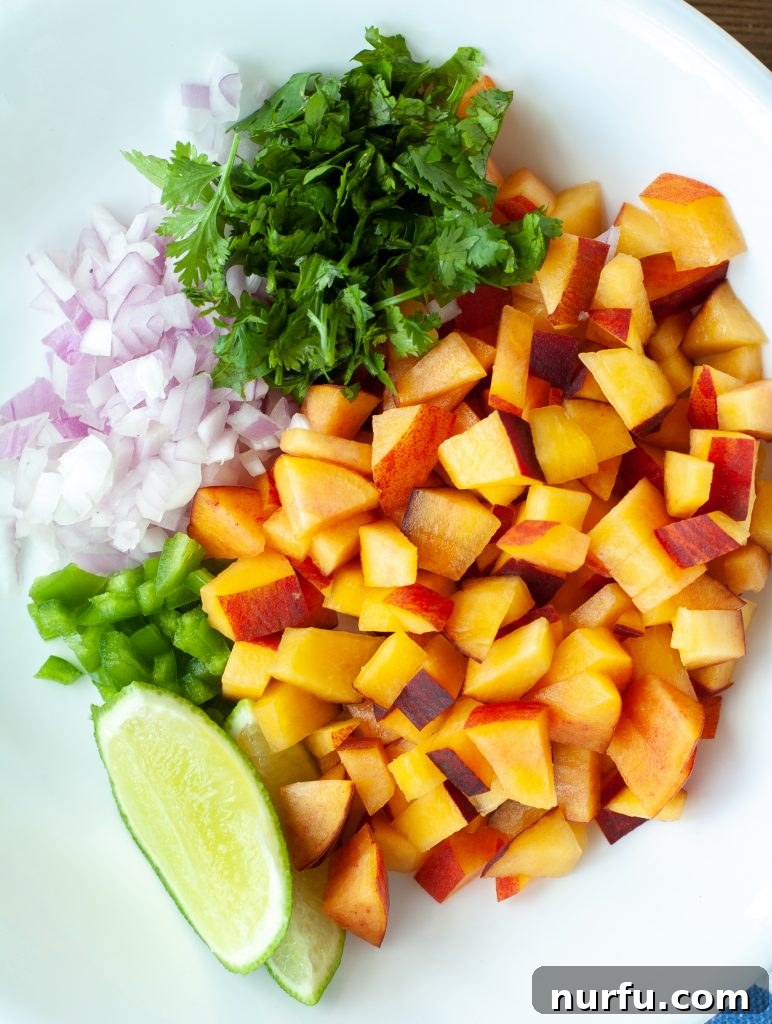 A vibrant selection of fresh ingredients laid out, including diced peaches, red onion, cilantro, and a whole jalapeño, ready to be transformed into a delicious salsa.