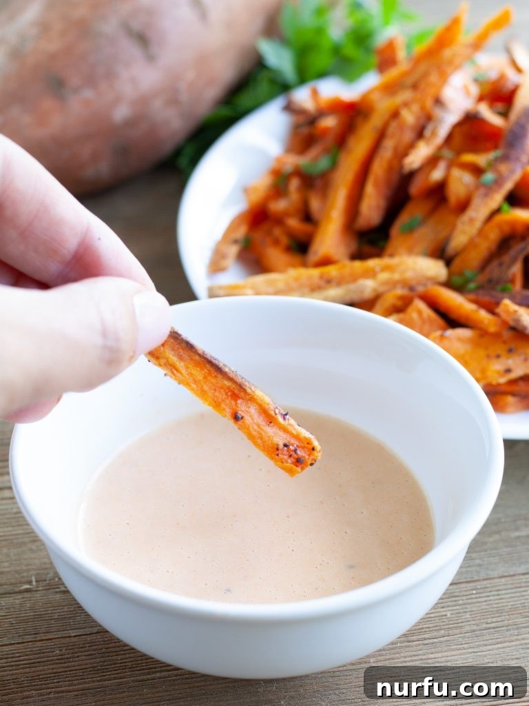 dipping fries Hand dipping a sweet potato fry into sauce