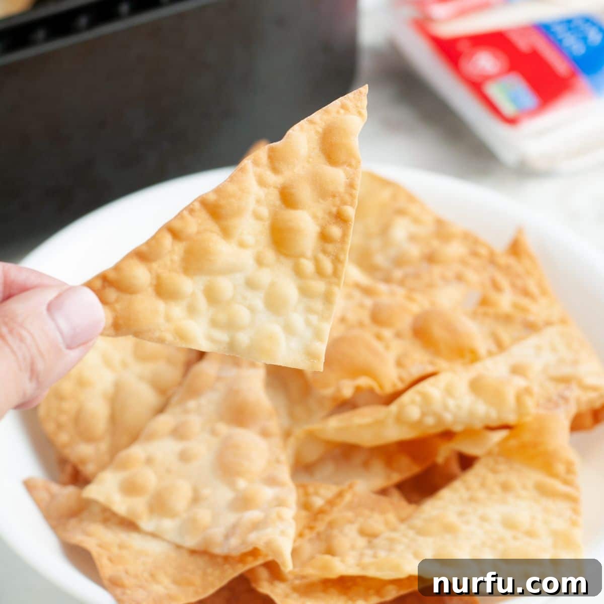 Effortless Air Fryer Wonton Crisps 2 A bowl brimming with golden, crispy air fryer wonton chips, ready for dipping.