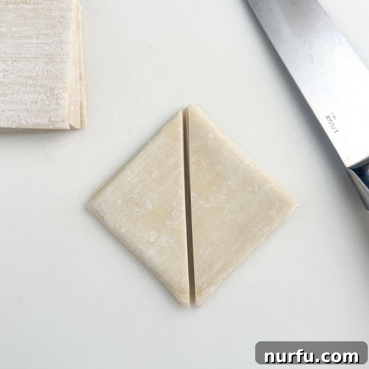 Effortless Air Fryer Wonton Crisps 4 Wonton wrappers precisely cut in half diagonally, ready for air frying.