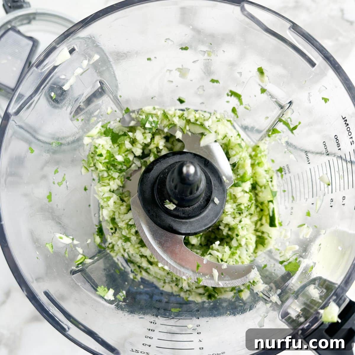 Zesty Zucchini Salsa 5 Food processor with finely chopped zucchini, onion, garlic, jalapeno, and cilantro, showing a uniform consistency.