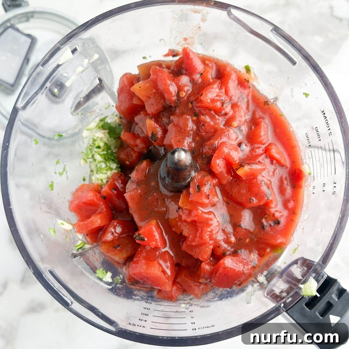 Zesty Zucchini Salsa 6 Opened food processor with finely chopped vegetables, now with fire-roasted tomatoes added on top, ready for final pulsing.