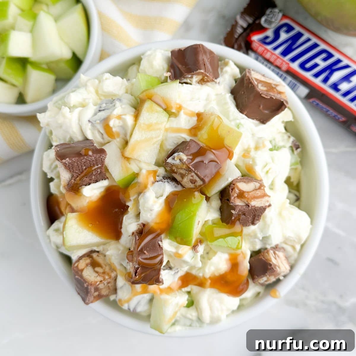 Snickers Caramel Apple Dream 7 Close-up shot of a bowl of Snickers apple salad, showing its creamy texture and chunky ingredients.