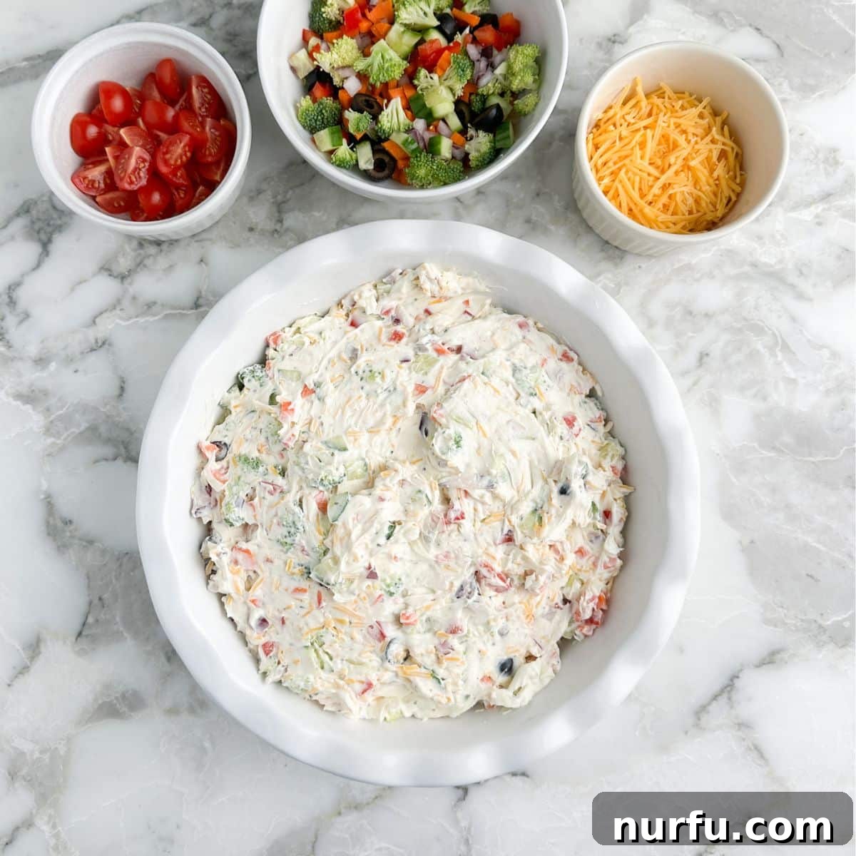 Garden Fresh Pizza Dip 6 Baking dish with vegetable dip, bowl of chopped vegetables, tomatoes, and shredded cheese.