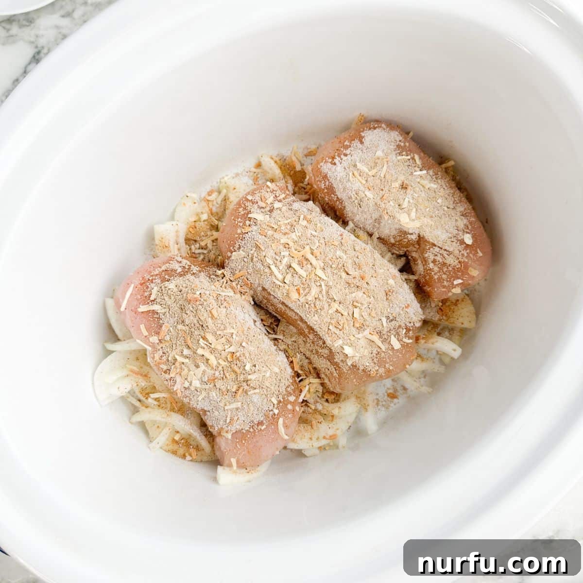 Caramelized French Onion Chicken 4 Slow cooker with onions, chicken breasts, and seasonings.