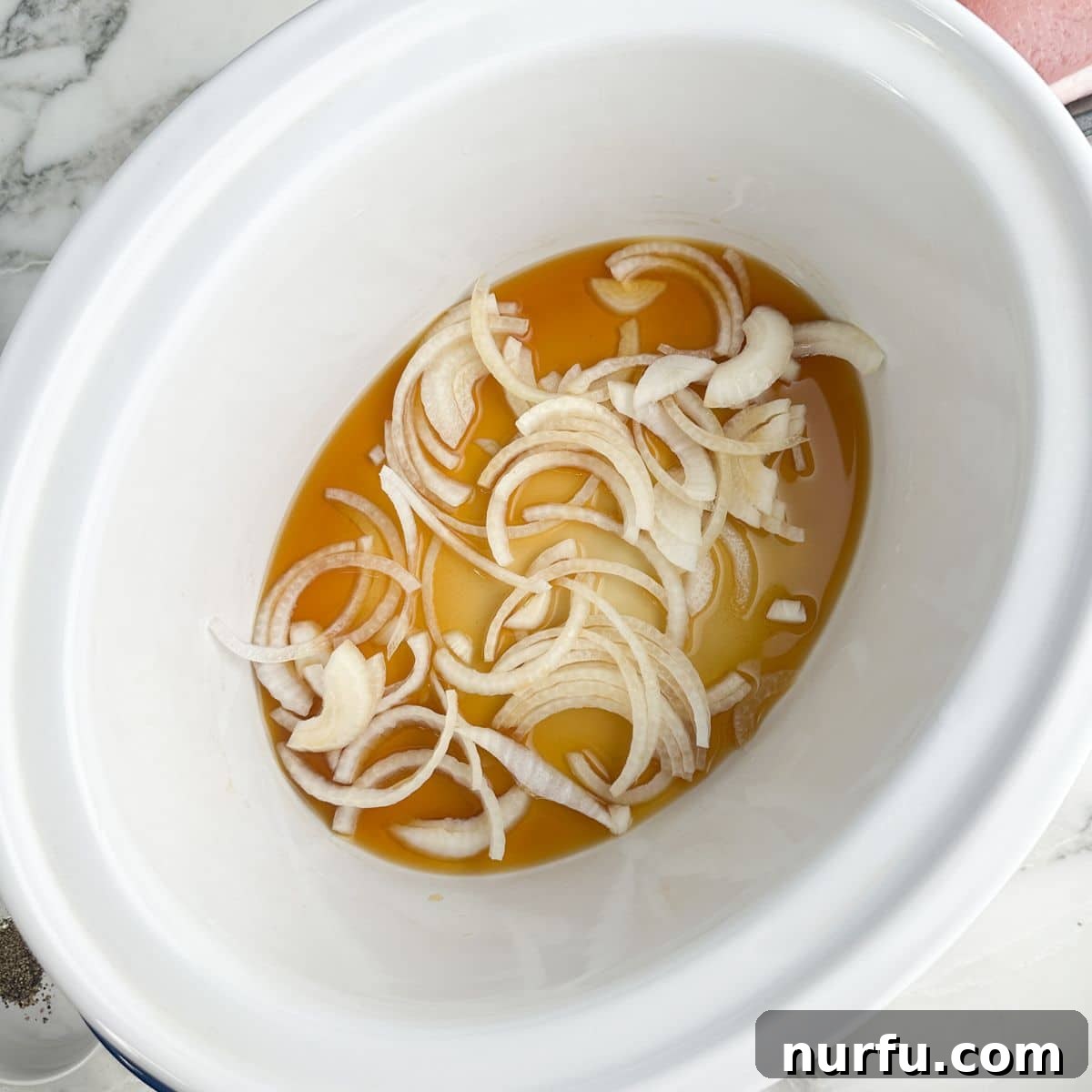Tender Slow Cooker Pork and Apples 4 Slow cooker with beef broth and perfectly sliced onions forming a flavorful base.
