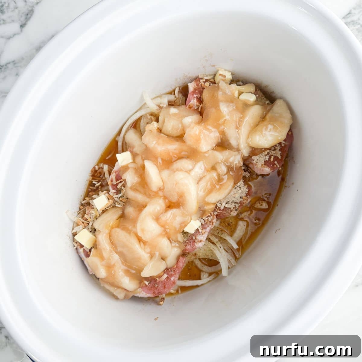 Tender Slow Cooker Pork and Apples 7 Slow cooker now filled with pork chops and a generous layer of apple pie filling.