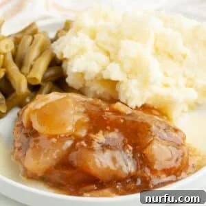 Tender Slow Cooker Pork and Apples 9 Plate with apple pie pork chop, mashed potatoes, and green beans.