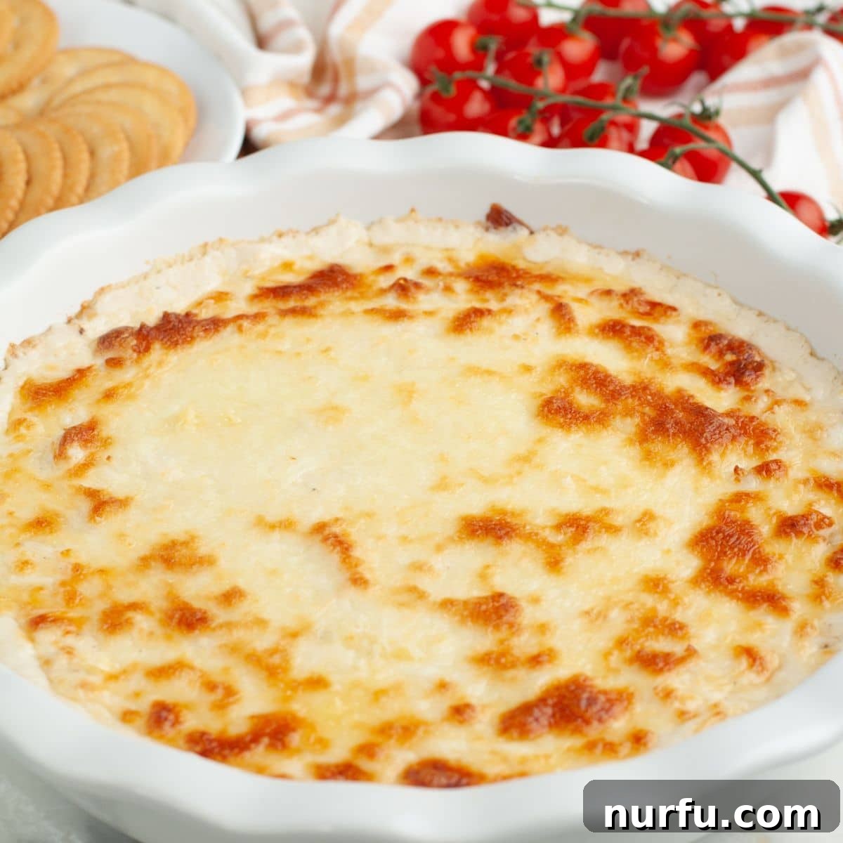 Ultimate Chicken Alfredo Dip 6 Baking dish with freshly baked, hot and bubbly chicken alfredo dip, golden brown on top, ready for serving.