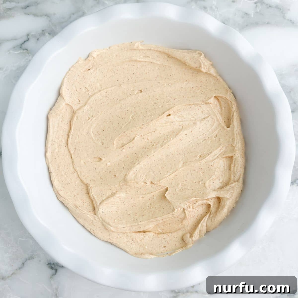 Stacked Salsa Sensation 5 A pie dish with the creamy, seasoned cream cheese mixture evenly spread across the bottom, ready for the next layer.
