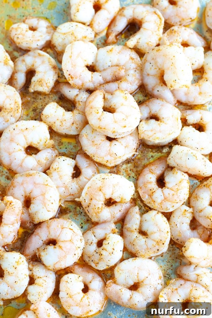 Close-up of baked Cajun shrimp on a baking sheet, ready for meal prep