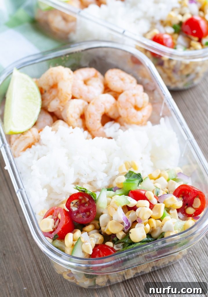 Meal prep container featuring Cajun shrimp, white rice, and a colorful corn and tomato salad