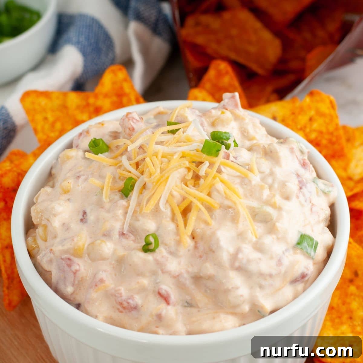 A bowl of Doritos dip beautifully garnished with a sprinkle of shredded cheese on top.