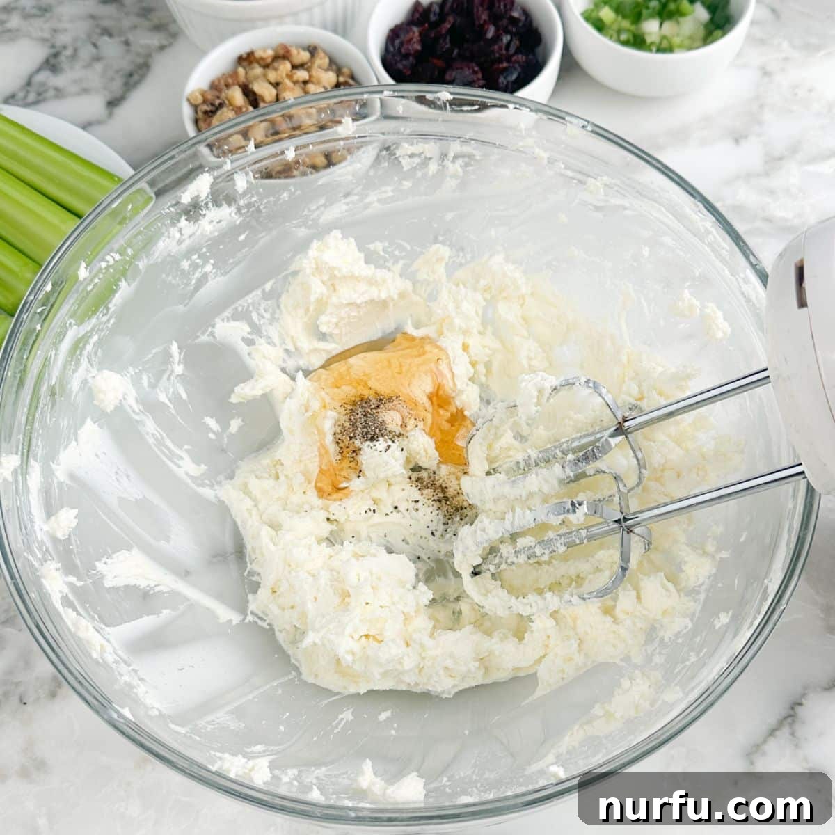 Creamy Celery Crunch 4 A bowl of whipped cream cheese blended smoothly with honey and various seasonings, ready for the next additions.