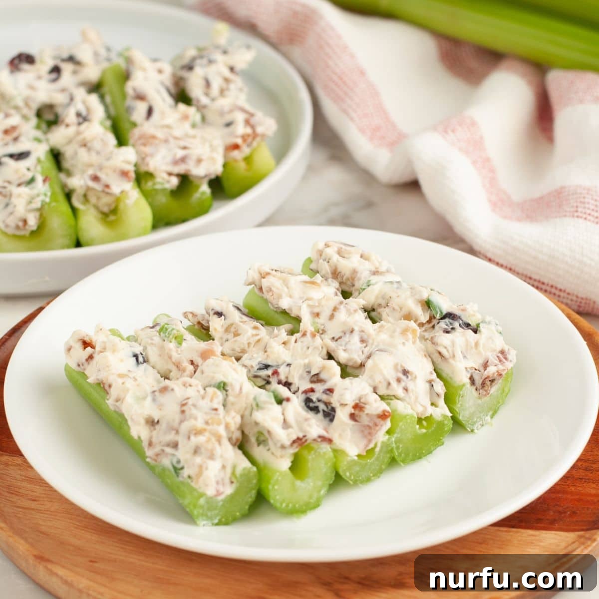 Creamy Celery Crunch 8 An elegantly arranged plate of perfectly stuffed celery pieces, showcasing the vibrant filling against the crisp green stalks, ready to be enjoyed.