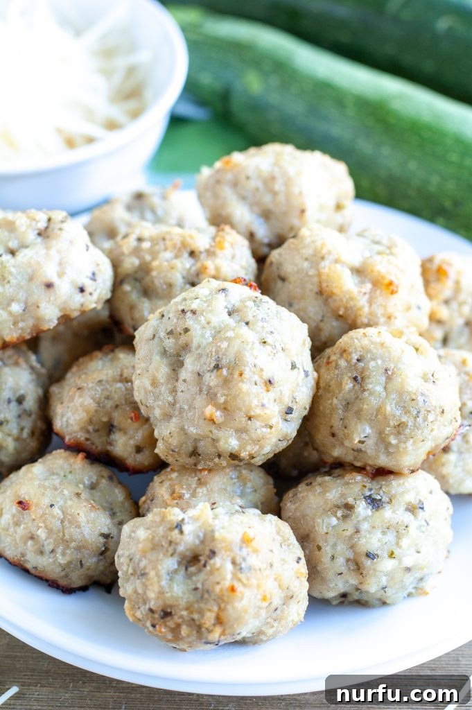 Stacked chicken meatballs on a white plate, ready to be served.