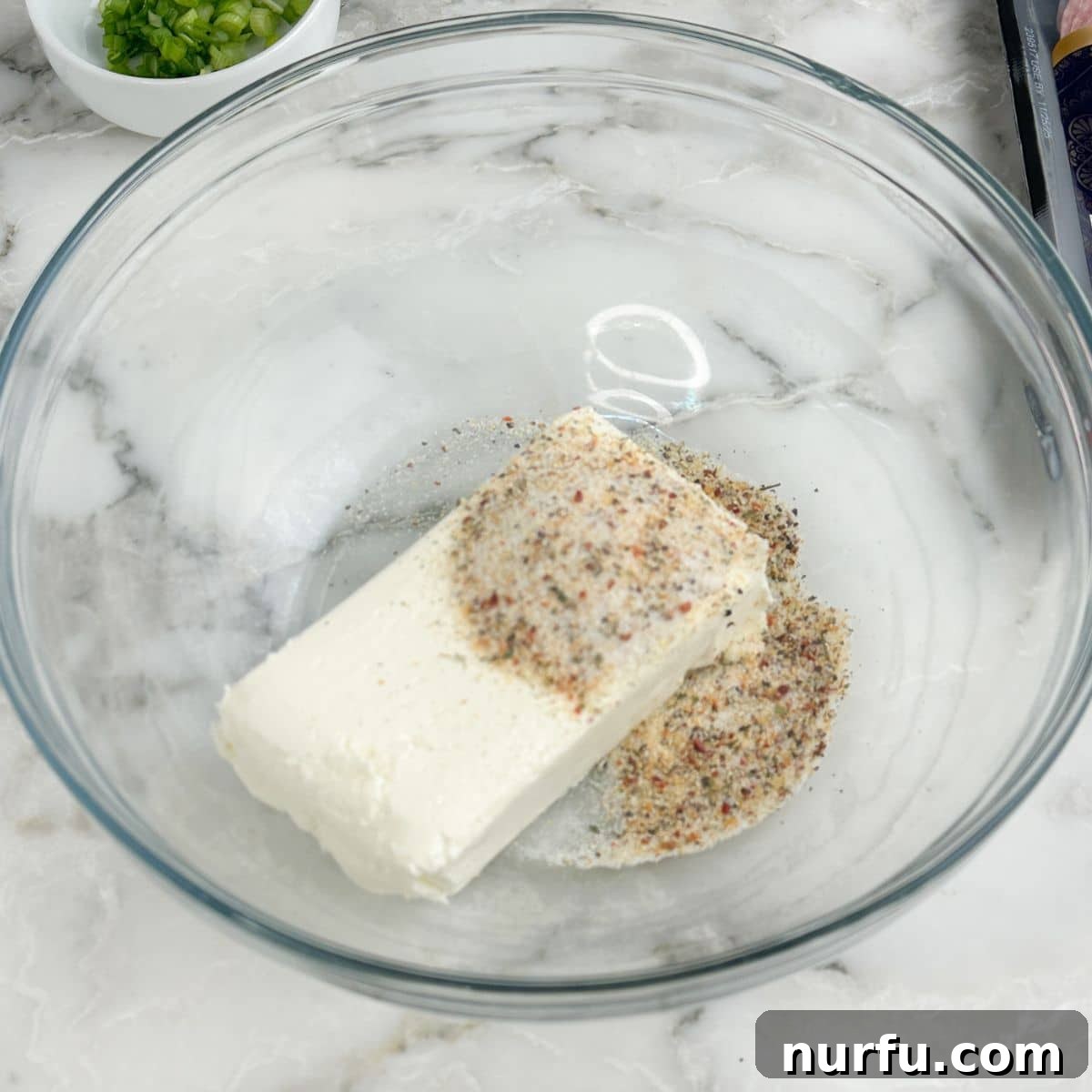 Savory Salami Bites 4 Bowl of softened cream cheese and Italian seasoning being mixed.