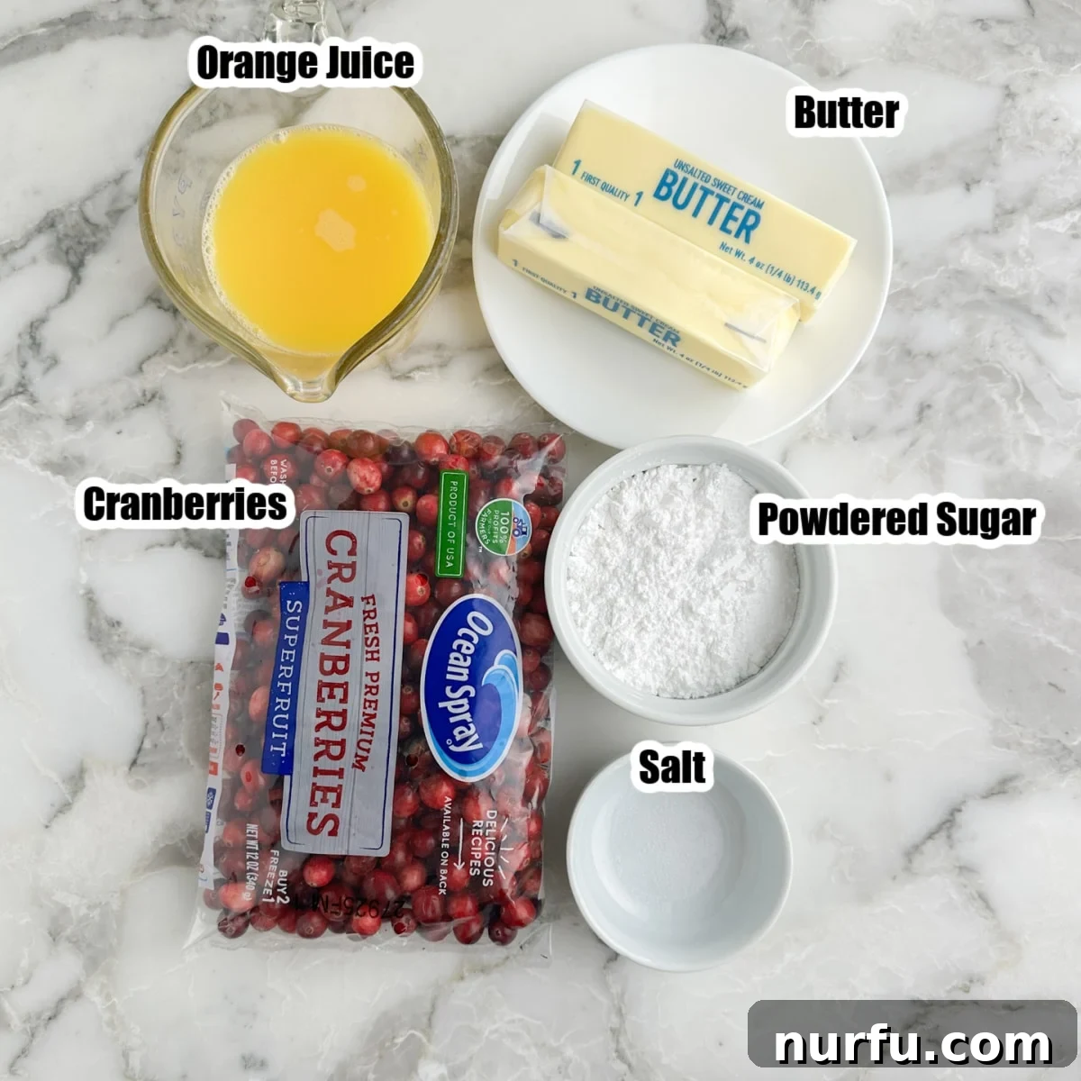 Zesty Cranberry Compound 3 Fresh cranberries, a bottle of orange juice, a stick of softened butter, powdered sugar, and a pinch of salt laid out on a kitchen counter, ready for making cranberry butter.