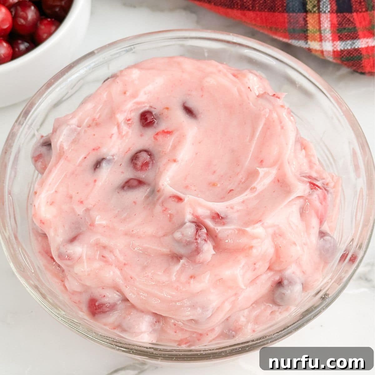 Zesty Cranberry Compound 6 A mixing bowl filled with the finished cranberry butter, featuring a creamy pink hue with visible flecks of cranberry, ready to be served.