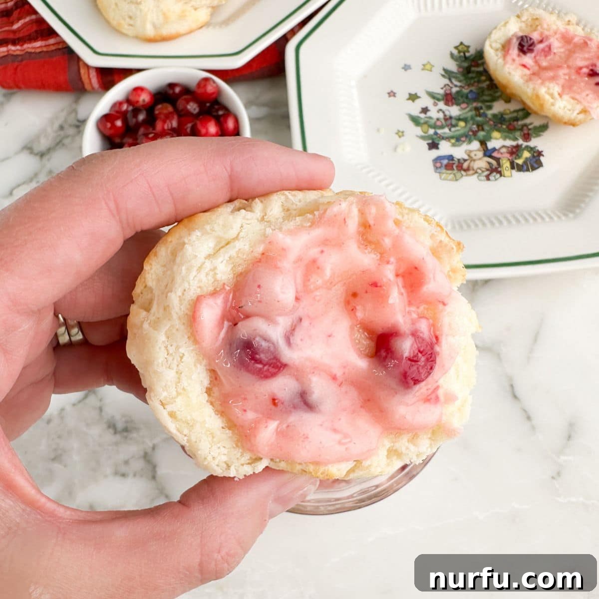 Zesty Cranberry Compound 7 A warm, fluffy biscuit sliced in half, generously spread with vibrant cranberry butter, ready to be enjoyed.