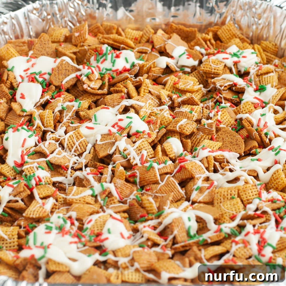 Gingerbread Holiday Crunch 2 Pan with festive Gingerbread Chex Mix, drizzled with white chocolate and colorful sprinkles, ready for the holidays.