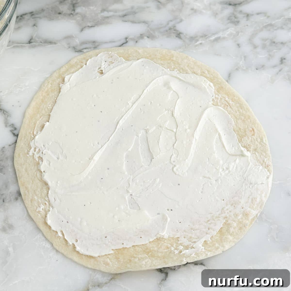 Clubhouse Pinwheel Bites 4 A large flour tortilla meticulously covered with a generous, creamy layer of the seasoned cream cheese and mayonnaise spread.