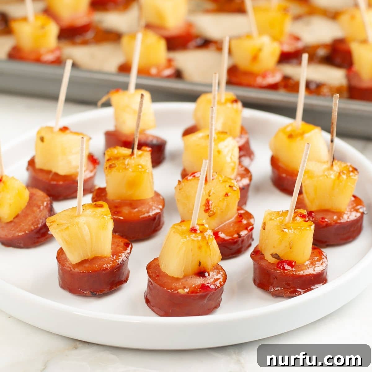 Golden Pineapple Kielbasa Poppers 8 Plate of finished pineapple kielbasa bites, garnished and ready to serve.
